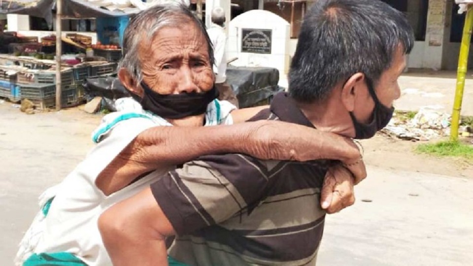 লকডাউন: ভাতা তুলতে মাকে কাঁধে তুলে ব্যাংকে গেলেন ছেলে