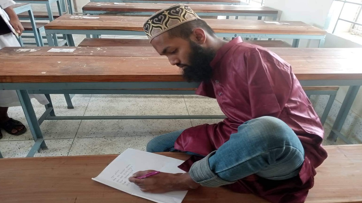 পা দিয়ে লিখে আলিম পরীক্ষা দিচ্ছেন কালুখালীর হাবিব