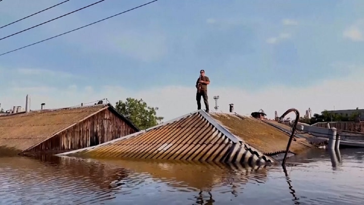 ডুবন্ত বাড়ির চালে উঠে বাদ্যযন্ত্র বাজিয়ে ভাইরাল যুবক