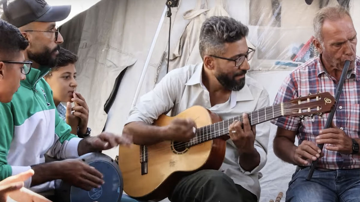 বোমার শব্দগুলোকে গিটারের সাহায্যে গানে পরিনত করছেন গাজার সংগীত শিক্ষক